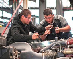 2 mechanics working on a car engine