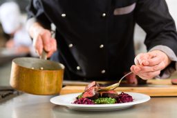 Chef serving dish in restaurant kitchen