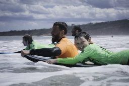 Men and kids learning to surf
